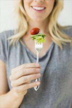 Woman holding salad on fork.
Photo : Jessica Peterson