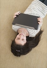 Girl (8-9) lying on floor using tablet pc.