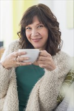 Portrait of woman holding hot drink.