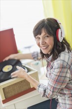 Woman listening to music on antique record player.