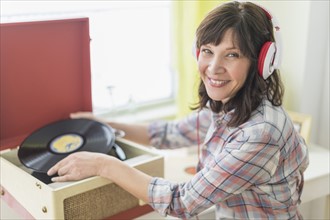 Woman listening to music on antique record player.