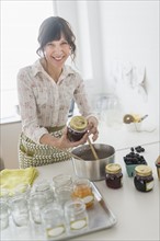 Woman making preserves in kitchen.