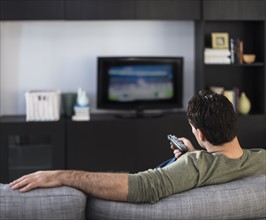 Rear view of man watching tv.