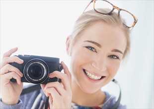 Portrait of woman holding camera.