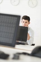 Young man sitting in front of desk and working.