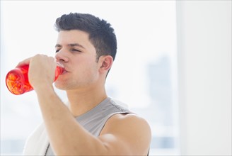 Young man drinking sports drink.