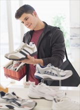 Young man looking at trainers in shoe shop.