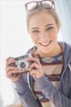 Portrait of woman holding vintage camera.