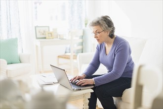 Mature woman paying bills via internet.