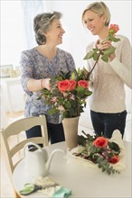 Two women arranging bouquet.