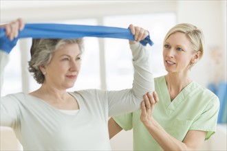 Mature woman exercising with personal trainer.