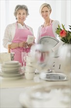 Two mature women preparing catering.