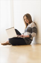Portrait of young woman using laptop.