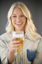 Portrait of young woman holding glass of beer. .
Photo : Jamie Grill