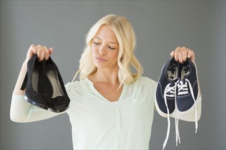 Portrait of young woman holding shoes.
Photo : Jamie Grill