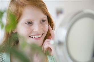 Girl (12-13) applying moisturizer.
Photo : Jamie Grill