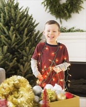 Portrait of boy (6-7) holding Christmas lights.
Photo : Daniel Grill