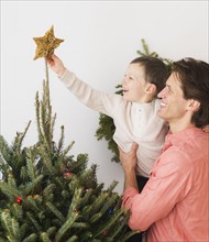 Man with kid (6-7) decorating Christmas tree.
Photo : Daniel Grill