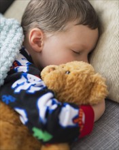 Boy (6-7) holding teddy bear during sleep.
Photo : Daniel Grill