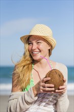 Young woman on beach drinking coconut juice. Jupiter, Florida, USA.
Photo : Daniel Grill