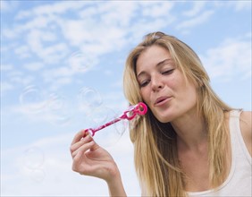 Young woman blowing bubbles.
Photo : Daniel Grill