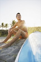 Young man sitting on beach with surfboard. Jupiter, Florida, USA.
Photo : Daniel Grill