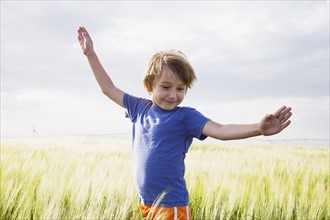 Boy (4-5) standing in grass with raised arms. Colorado, USA.
Photo : Maisie Paterson