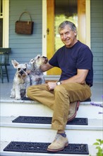 Man with his schnauzers sitting on porch. Albany, New York State, USA.
Photo : Kelly