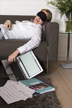 Woman sleeping on sofa while working at home.
Photo : Mark de Leeuw