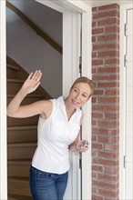 Woman opening door and waving.
Photo : Mark de Leeuw