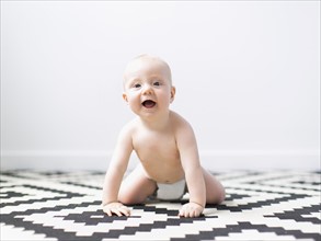 Portrait of baby boy (2-5 months) crawling.
Photo : Jessica Peterson