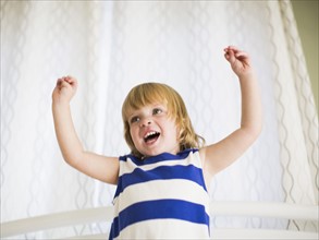 Portrait of girl (4-5) with arms raised.
Photo : Jessica Peterson