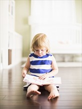 Girl (4-5) reading book.
Photo : Jessica Peterson