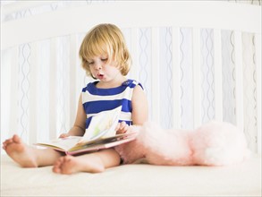 Girl (4-5) reading book.
Photo : Jessica Peterson