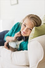 Portrait of woman on sofa with smart phone.