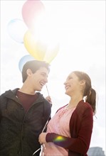 Young couple with balloons.