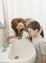 son (6-7) and mother brushing teeth.
