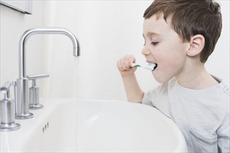 boy (6-7) brushing teeth.