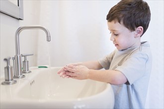 boy (6-7) washing hands.