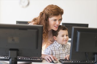boy (6-7) and teacher using computer.