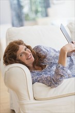 Woman lying on sofa and using laptop.