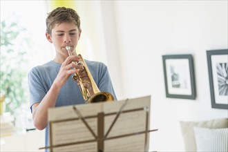 Teenage boy (16-17) playing trumpet.