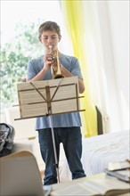 Teenage boy (16-17) playing trumpet.