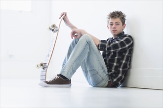Teenage boy (16-17) holding skateboard.