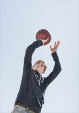 Teenage boy (16-17) playing basketball.