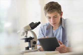 Teenage boy (16-17) using digital tablet in laboratory.