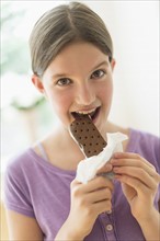girl (10-11) eating ice cream sandwich.