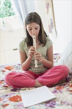 girl (10-11) playing flute.