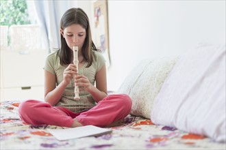 girl (10-11) playing flute.