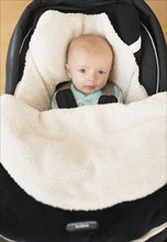 Portrait of baby boy (2-5 months) sitting in stroller.